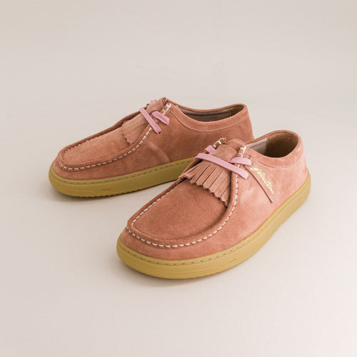 Pair of pink suede barefoot derbies with yellow soles on a light beige background