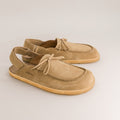 Pair of tan barefoot mules on a light gray background