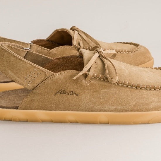 Pair of tan suede barefoot mules with 'fleeters' branding on a light gray background