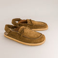 Pair of brown suede barefoot mules with decorative elements on a light gray background