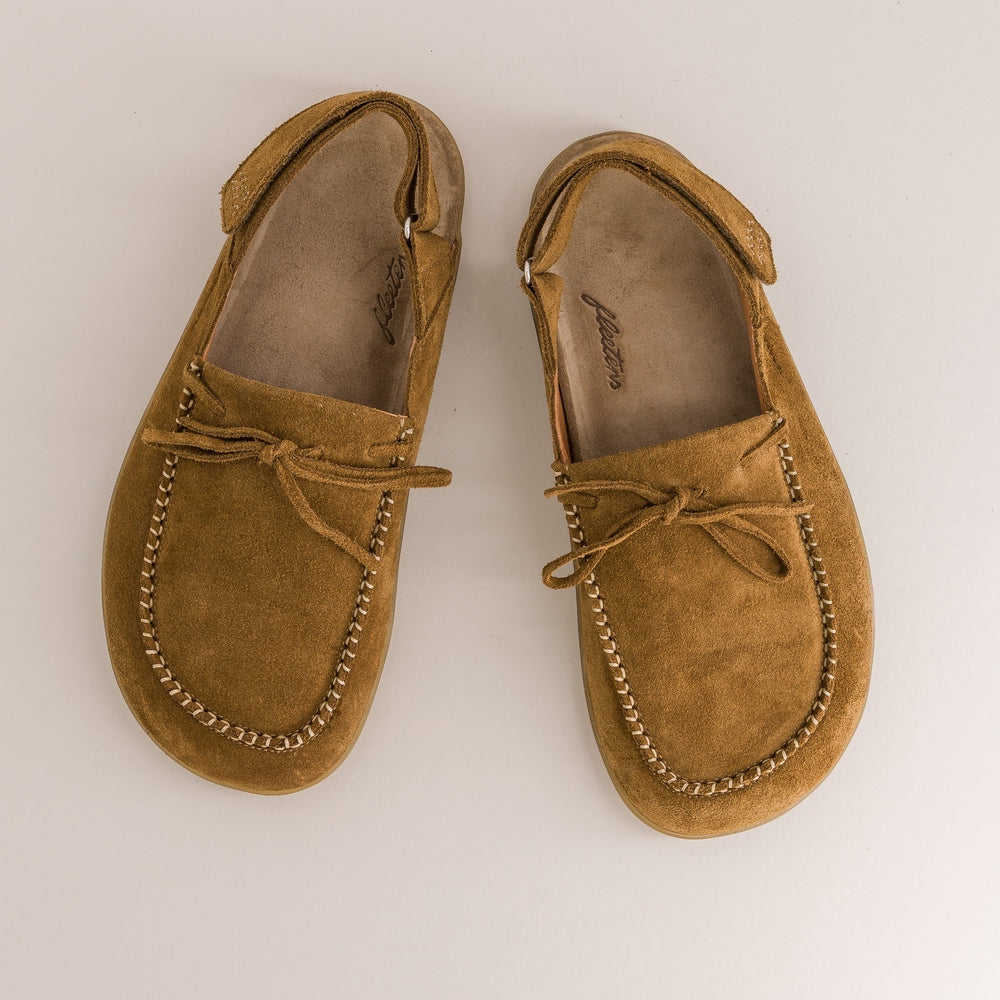 Pair of brown suede barefoot mules on a light beige background