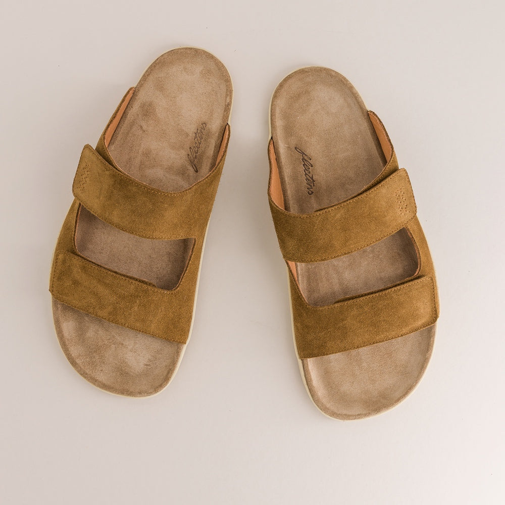 Pair of brown barefoot sandals on a light beige background