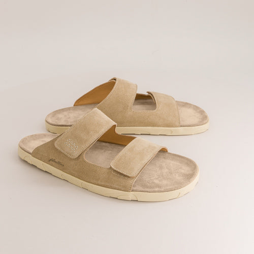 Pair of beige barefoot sandals on a light gray background