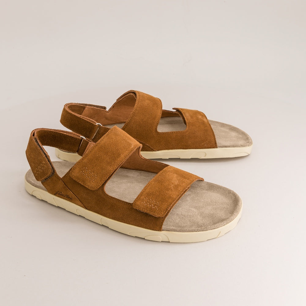 Pair of brown barefoot sandals on a light gray background