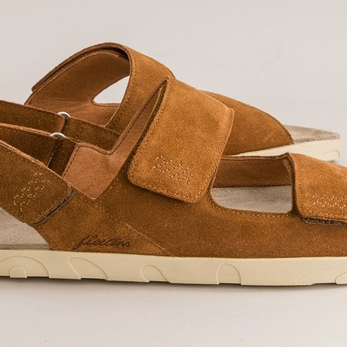 Brown barefoot sandal with velcro straps on a light gray background