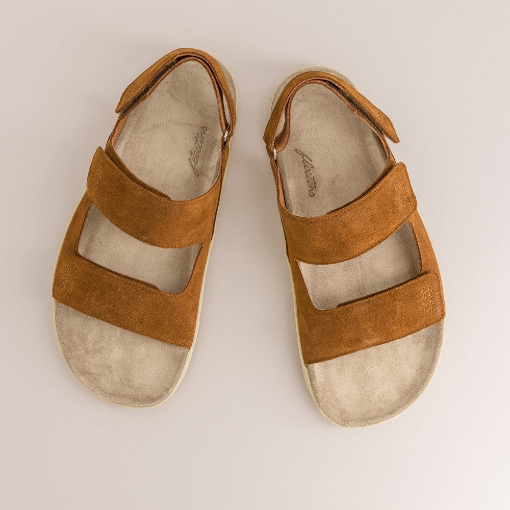 Pair of brown barefoot sandals on a light gray background