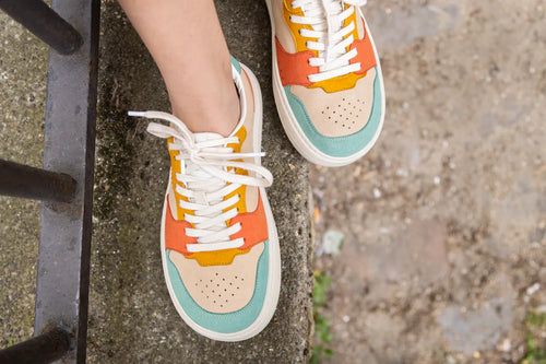 Colorful barefoot sneakers with a multicolor design on a concrete surface