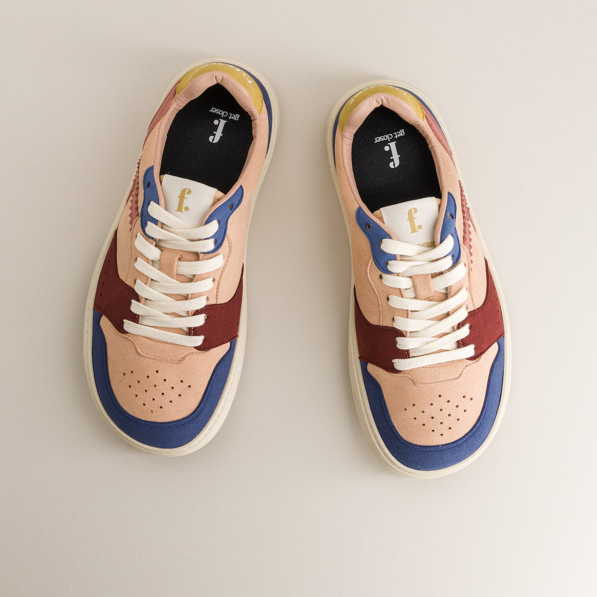 Pair of barefoot sneakers with a beige, brown, and blue color scheme on a light gray background.
