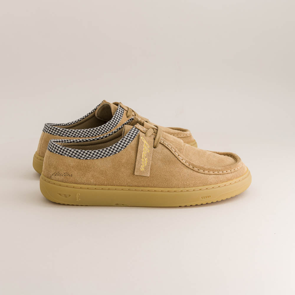 Tan casual barefoot shoe with checkered tongue on a light beige background