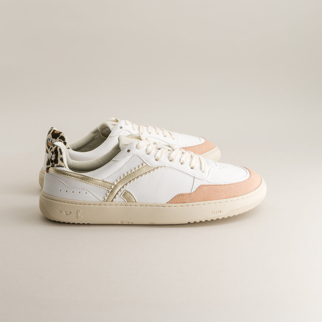 White and pink sneakers with leopard print details on a light gray background