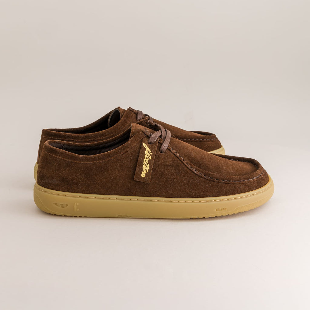 Brown suede derby shoes with a beige sole on a light gray background