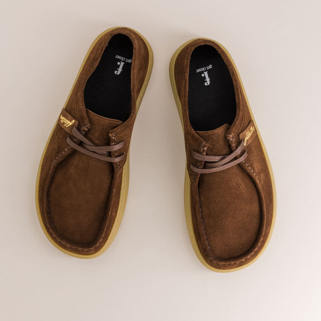Pair of brown suede barefoot shoes on a light gray background