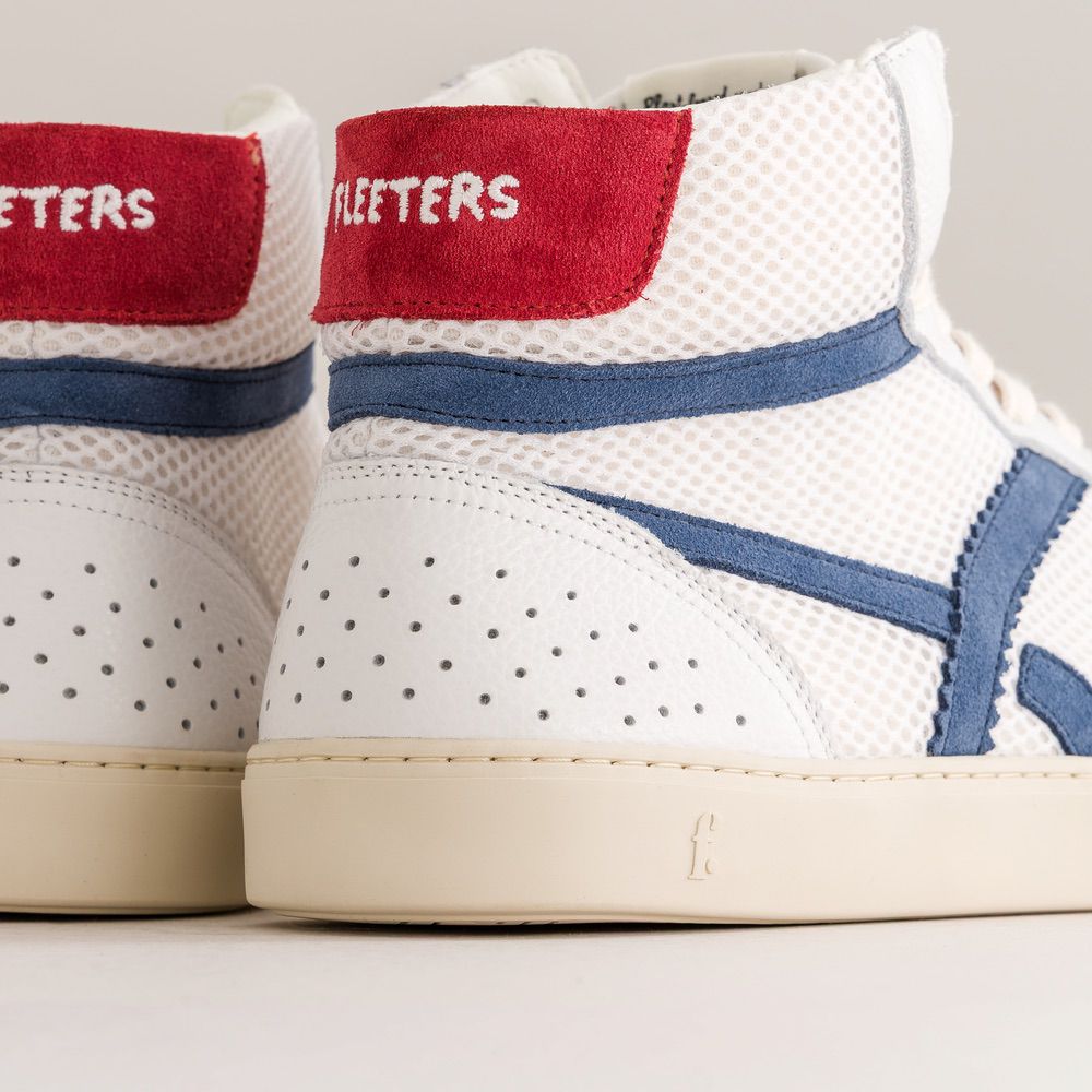 White sneakers with red and blue accents on a light gray background
