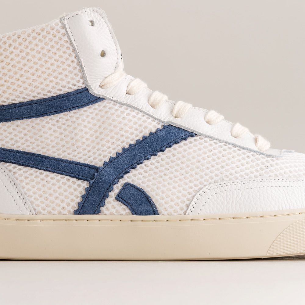 White sneaker with blue accents on a light gray background