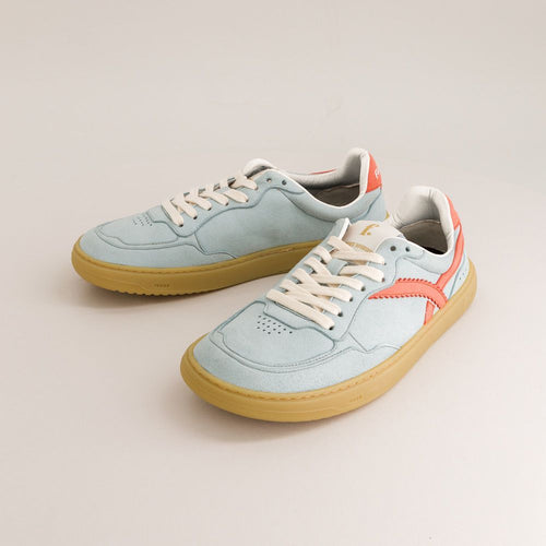 Pair of light blue barefoot sneakers with tan soles on a beige background