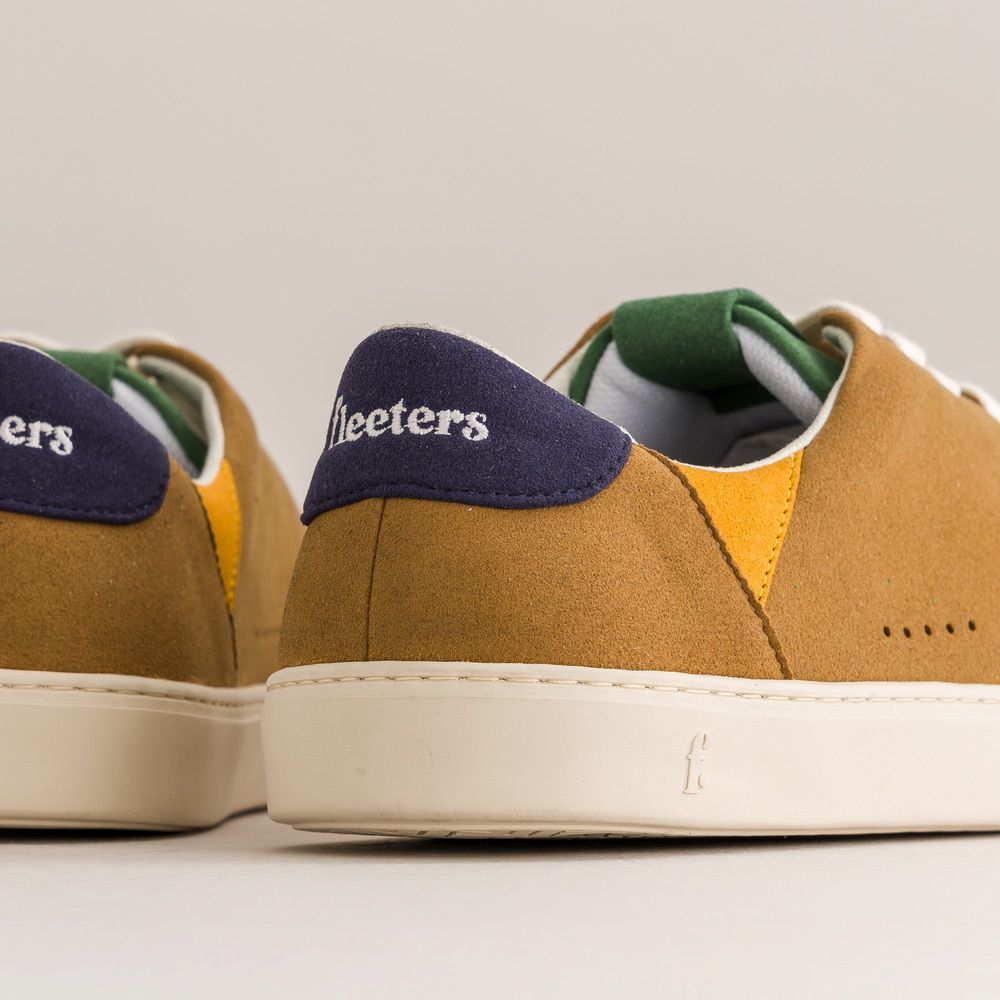 Brown sneakers with navy uppers on a light background