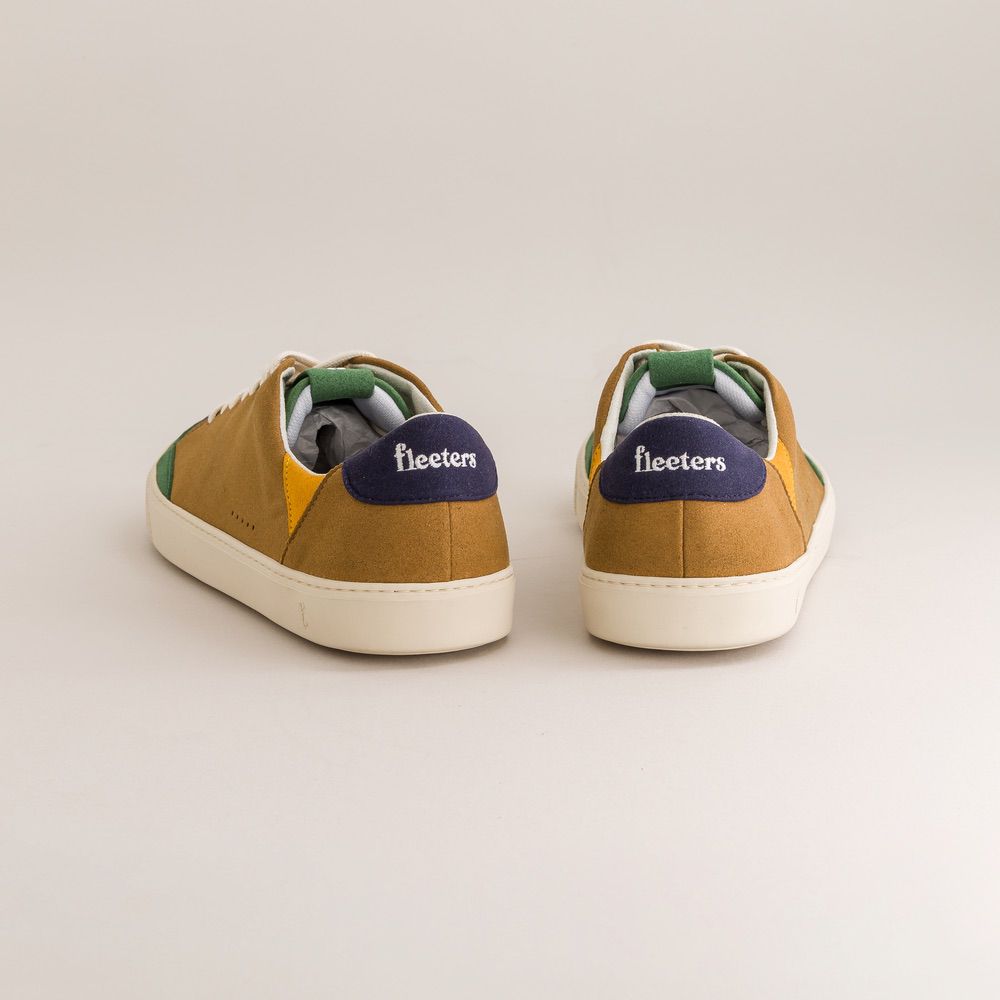 Pair of brown sneakers with green accents on a light gray background