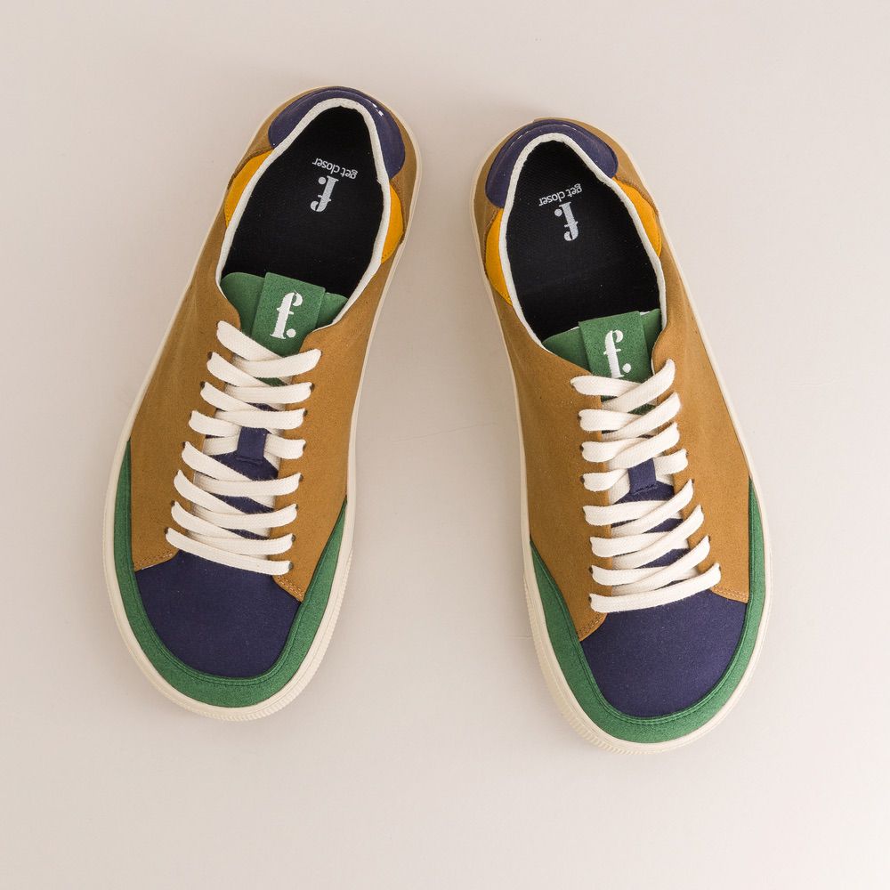 Pair of brown and blue barefoot sneakers with white laces on a light gray background