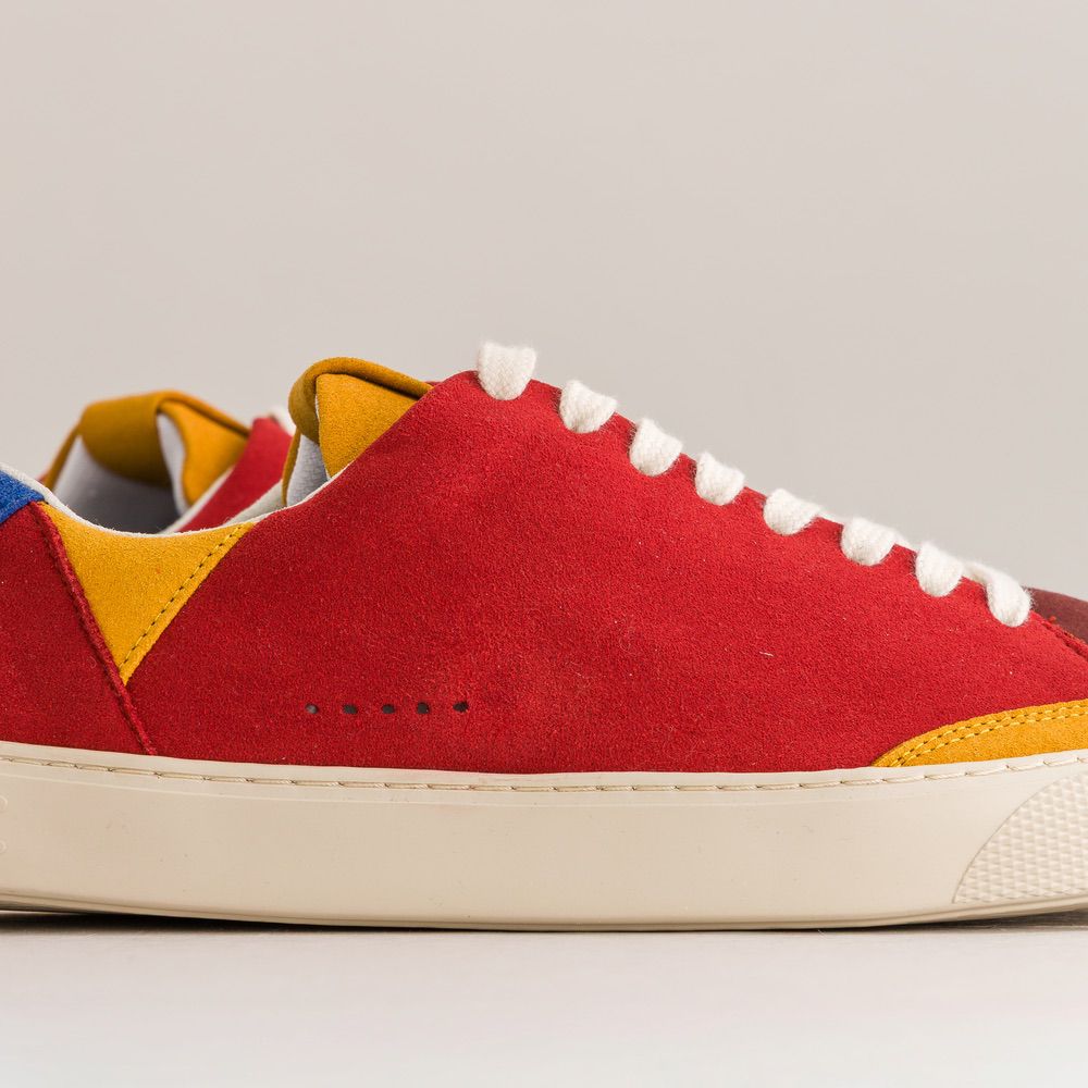 Colorful barefoot sneaker with a red base and multicolored accents on a light gray background