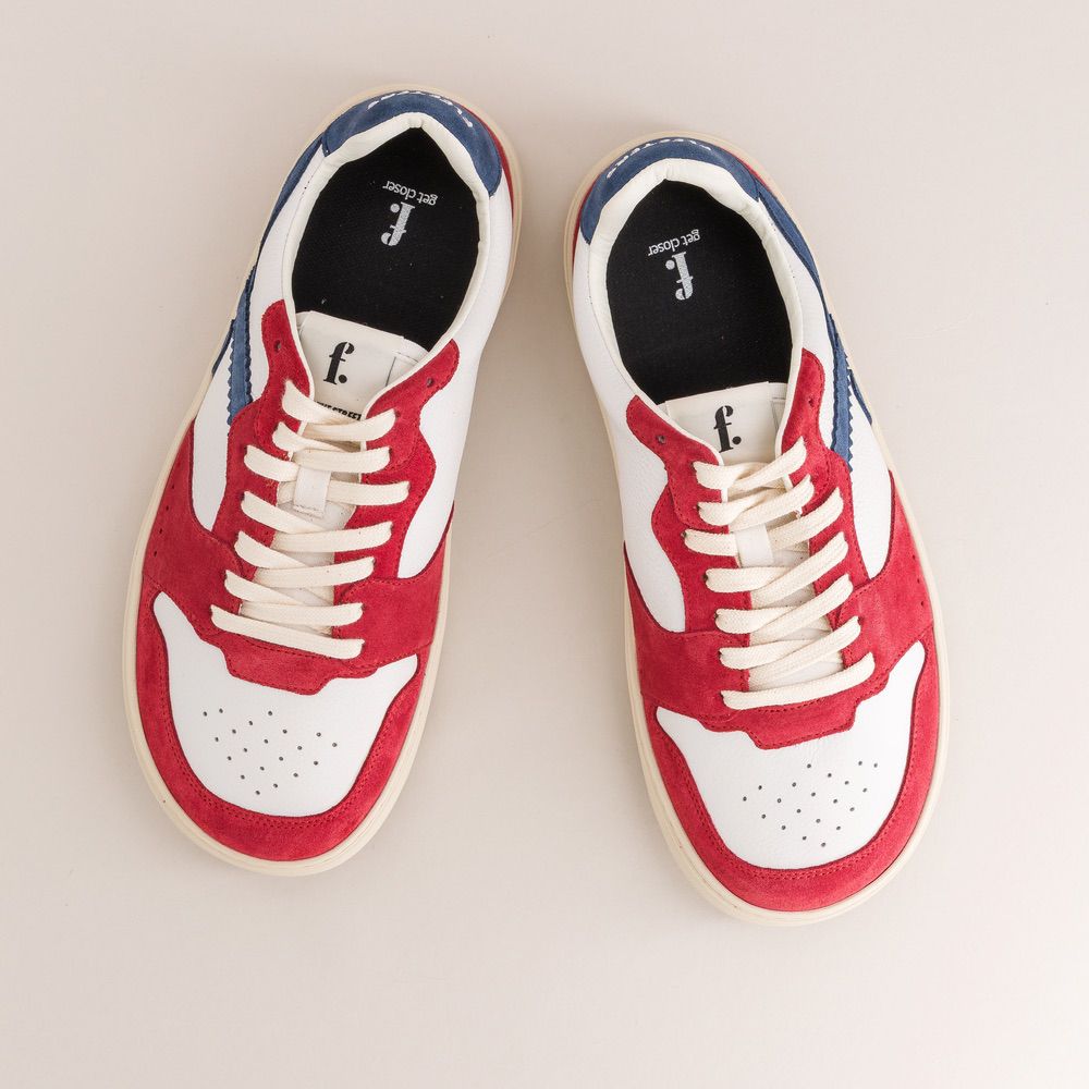 Red, white, and blue barefoot sneakers on a light gray background
