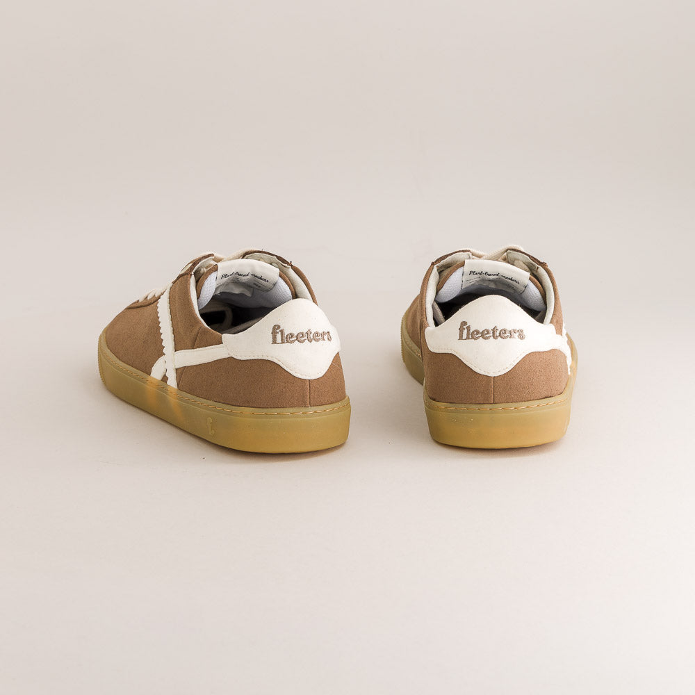 Pair of brown minimalist sneakers with white soles on a light gray background