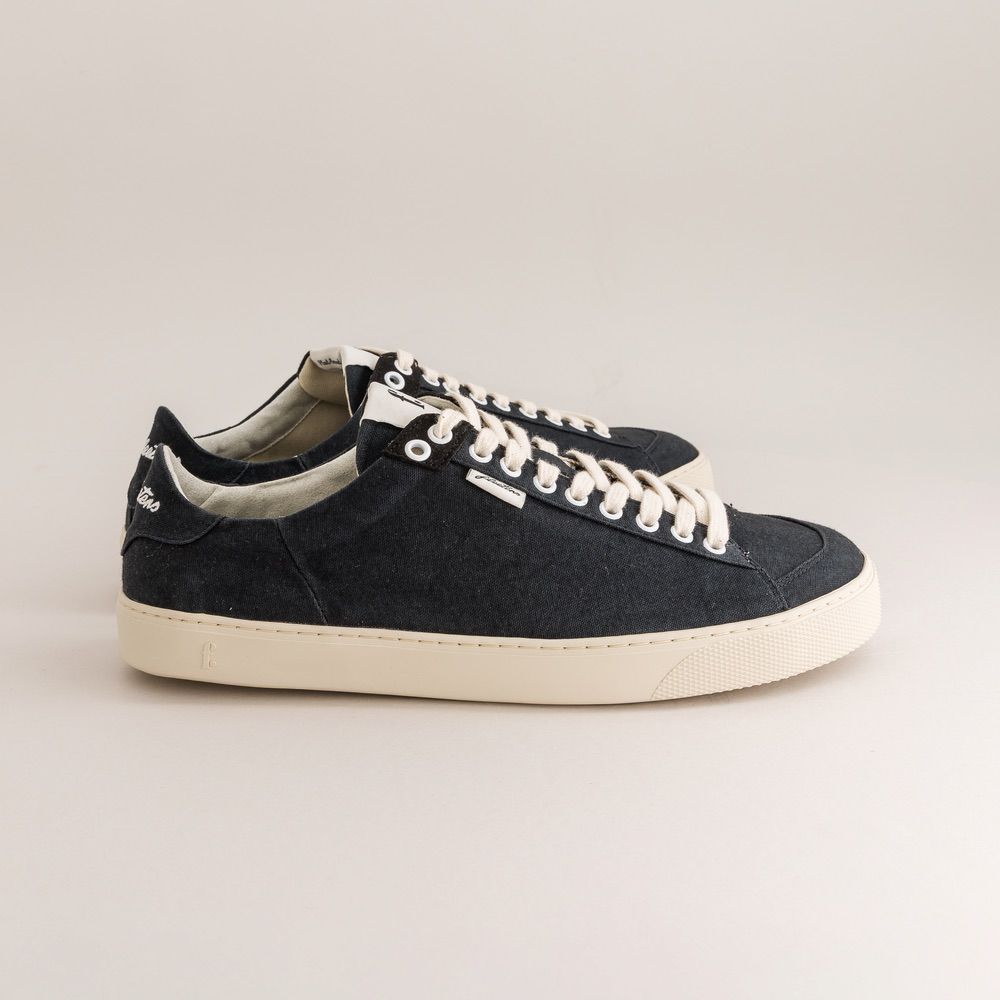 Black barefoot shoe with decorative strap on a white background