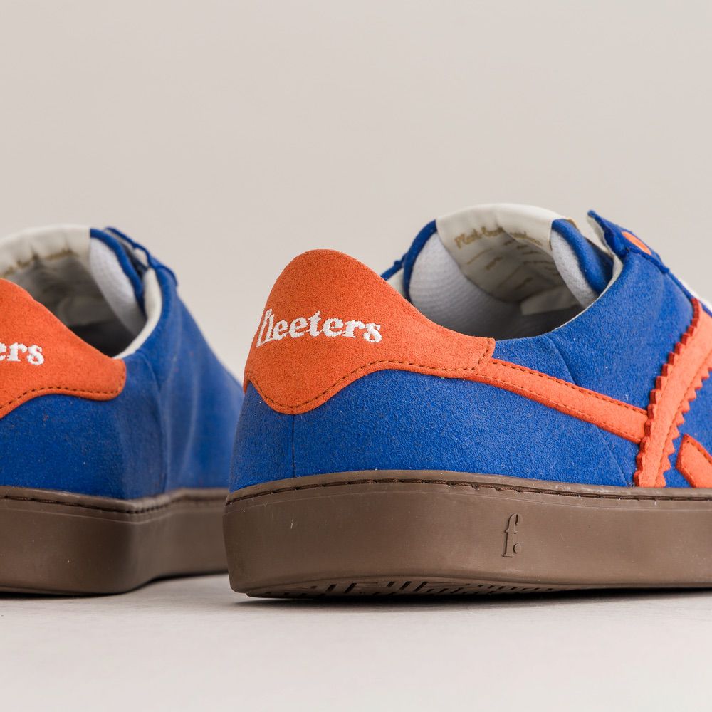 Blue and orange sneakers with 'Fleeters' branding on a light gray background