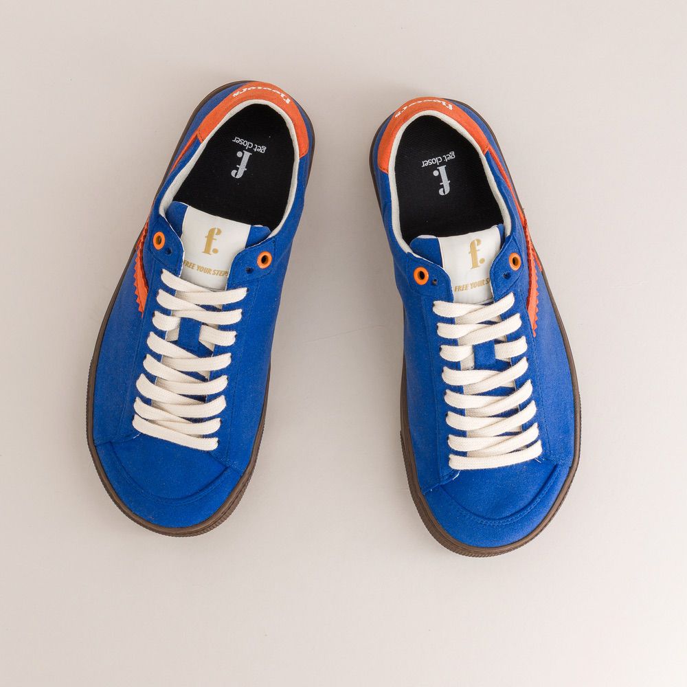 Pair of blue barefoot sneakers with white laces on a light gray background