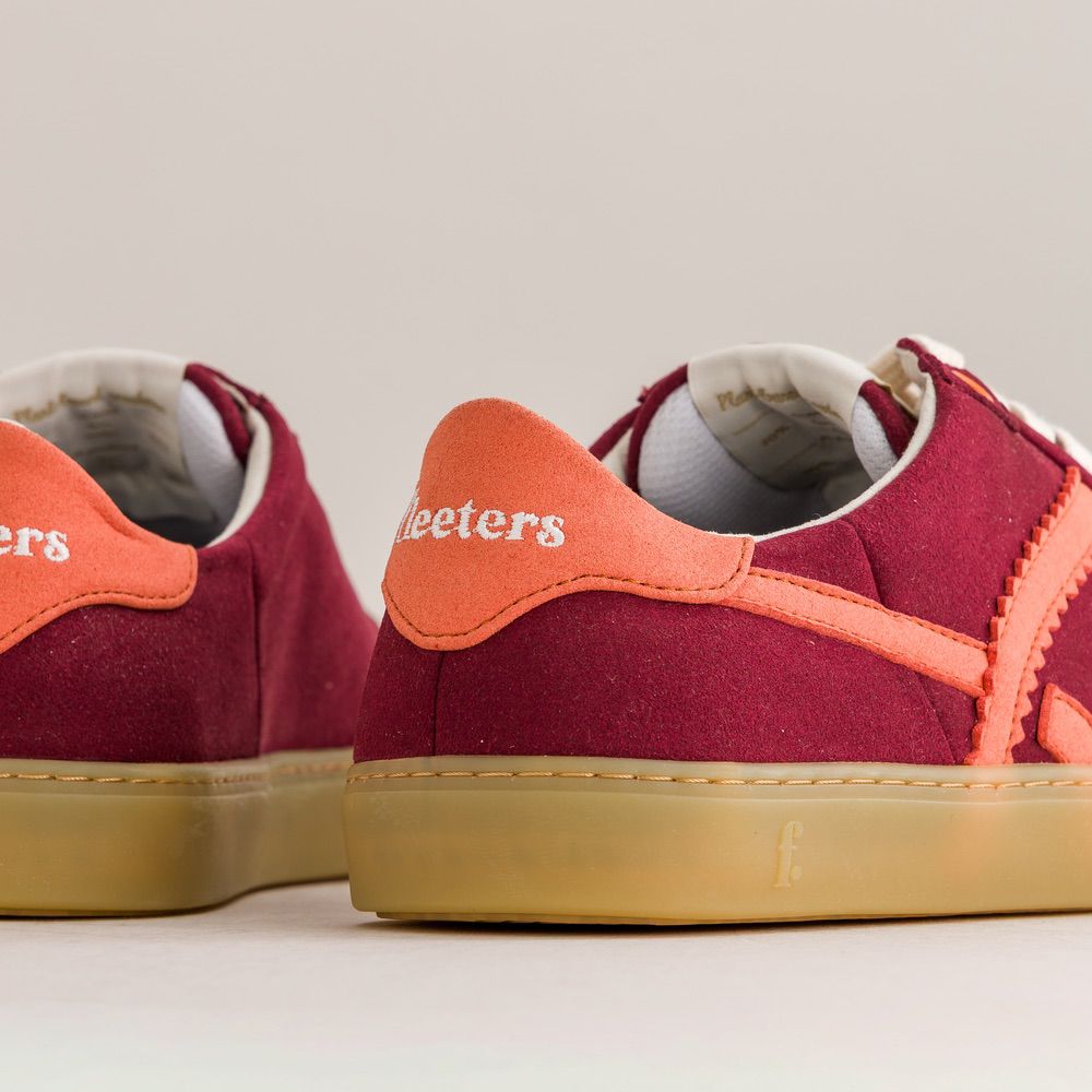 Red barefoot sneakers with orange accents on a light gray background
