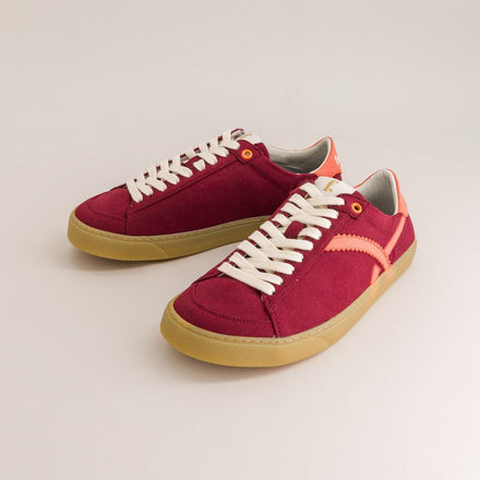 Red barefoot sneakers with white laces on a light gray background
