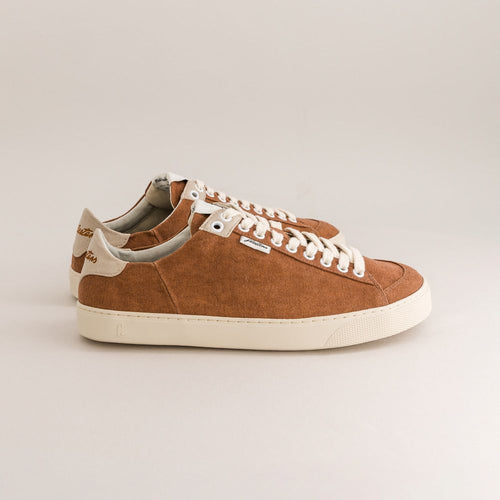 Brown minimalist sneaker with white laces on a light gray background