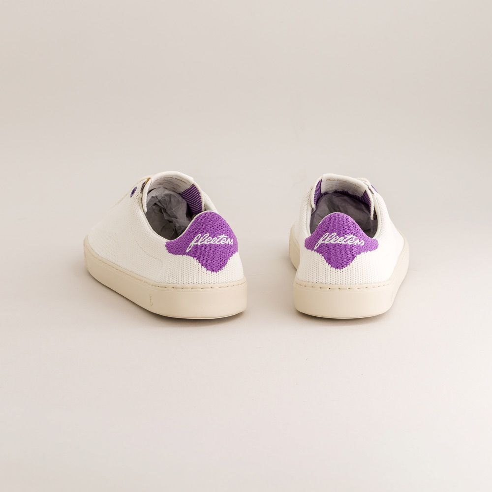 White knit barefoot sneakers with purple logo on a light gray background