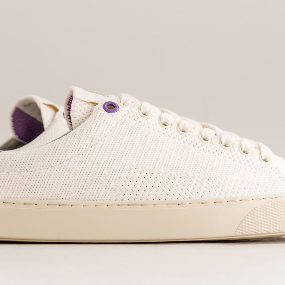 White knit barefoot sneaker with purple accents on a light gray background
