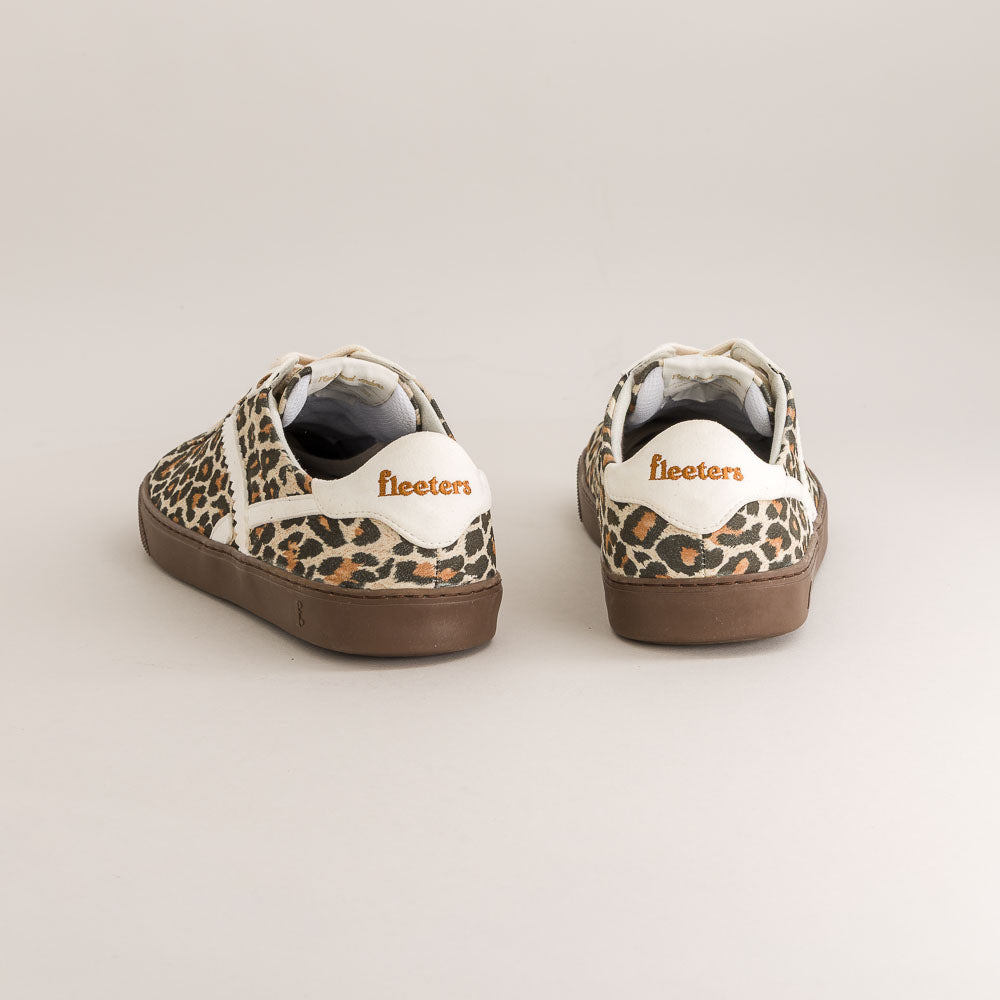 Pair of leopard print sneakers with brown soles on a light gray background