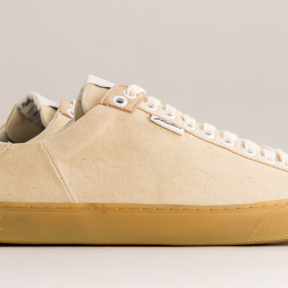 Beige barefoot sneaker with white laces on a light gray background