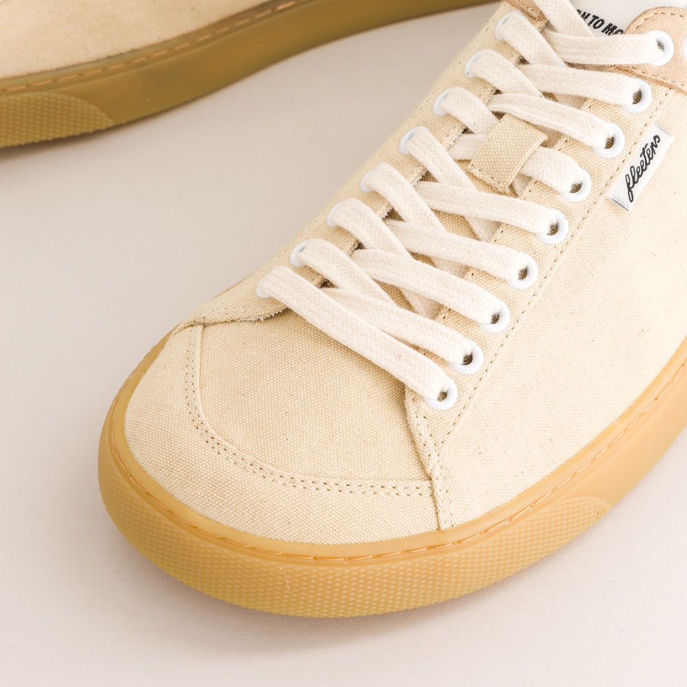 Beige barefoot sneaker with white laces on a light background