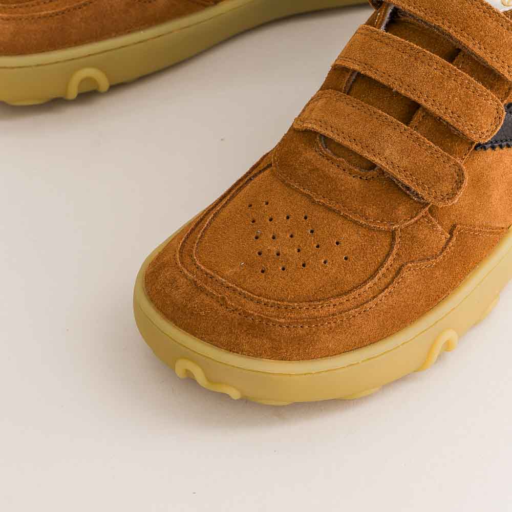Brown children's barefoot shoes with velcro straps on a light gray background
