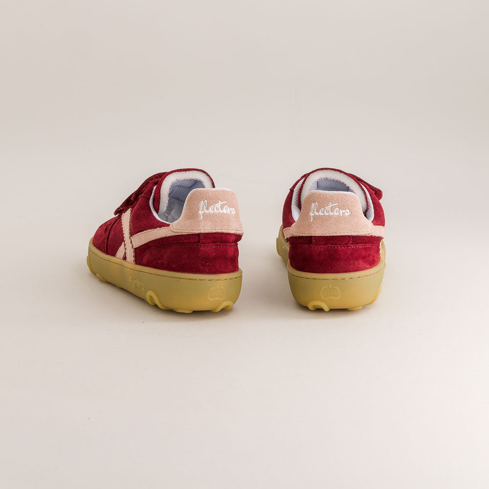 Red barefoot sneakers with yellow soles on a light gray background