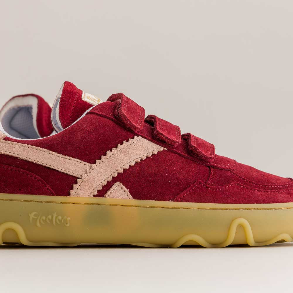 Red barefoot sneaker with yellow sole on a gray background