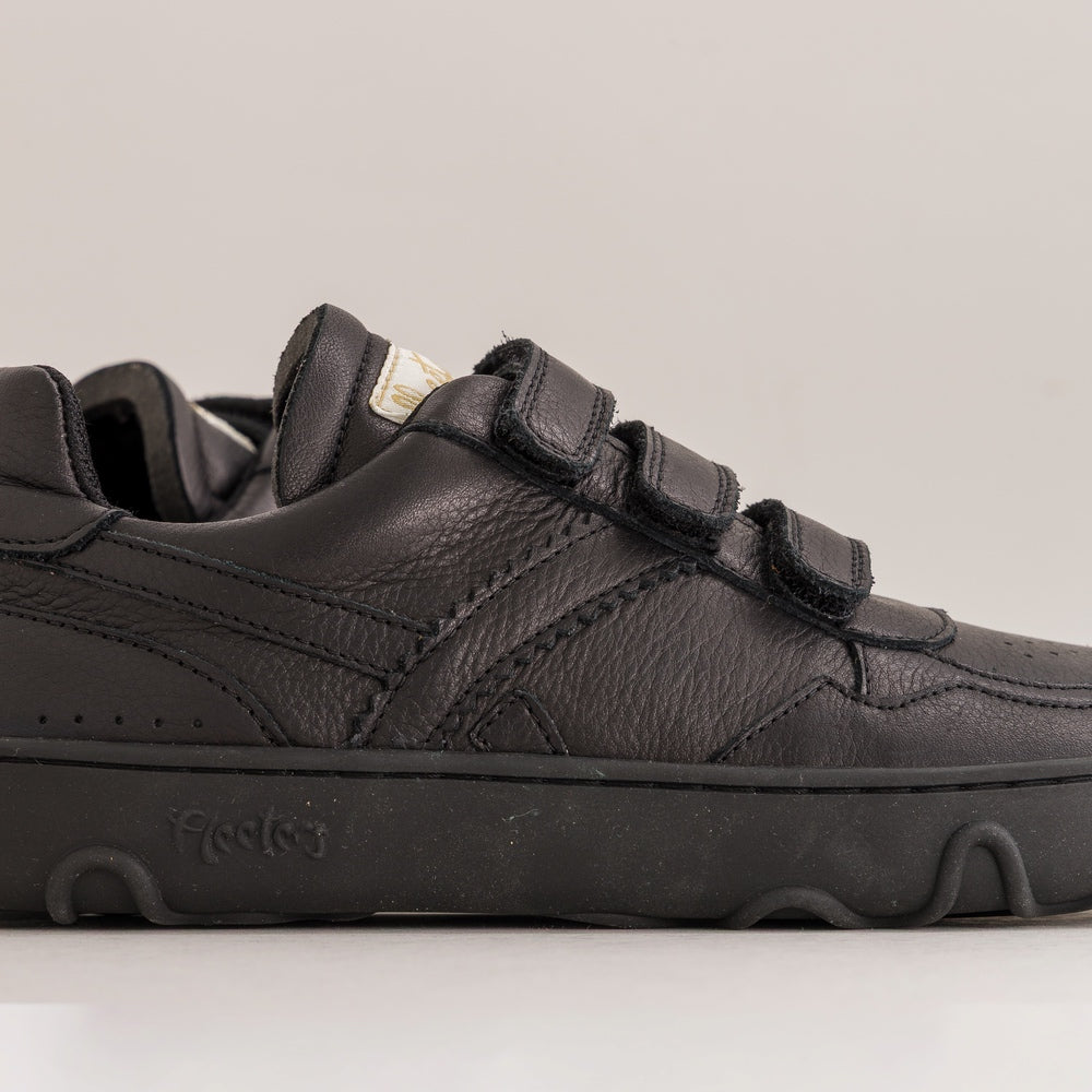 Black kids barefoot shoe with velcro straps on a light gray background