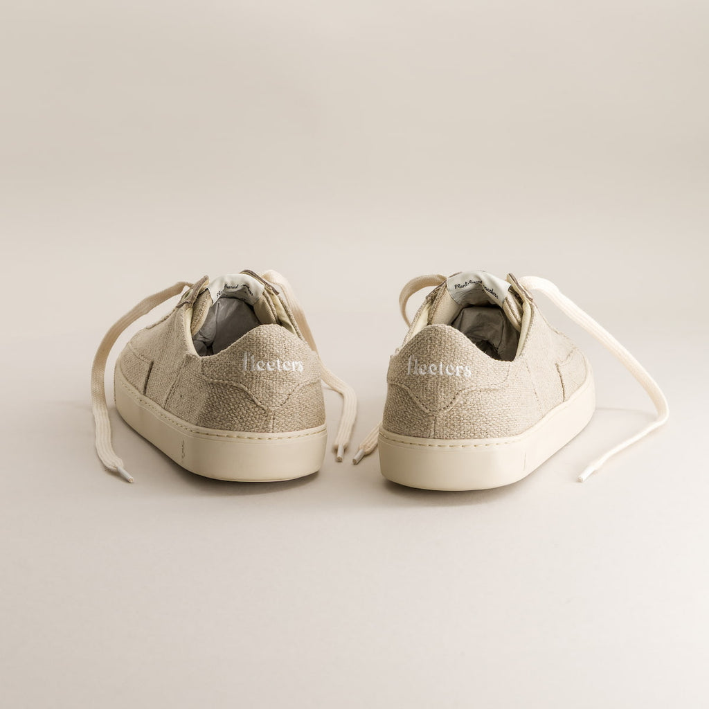 Pair of beige barefoot sneakers on a light gray background