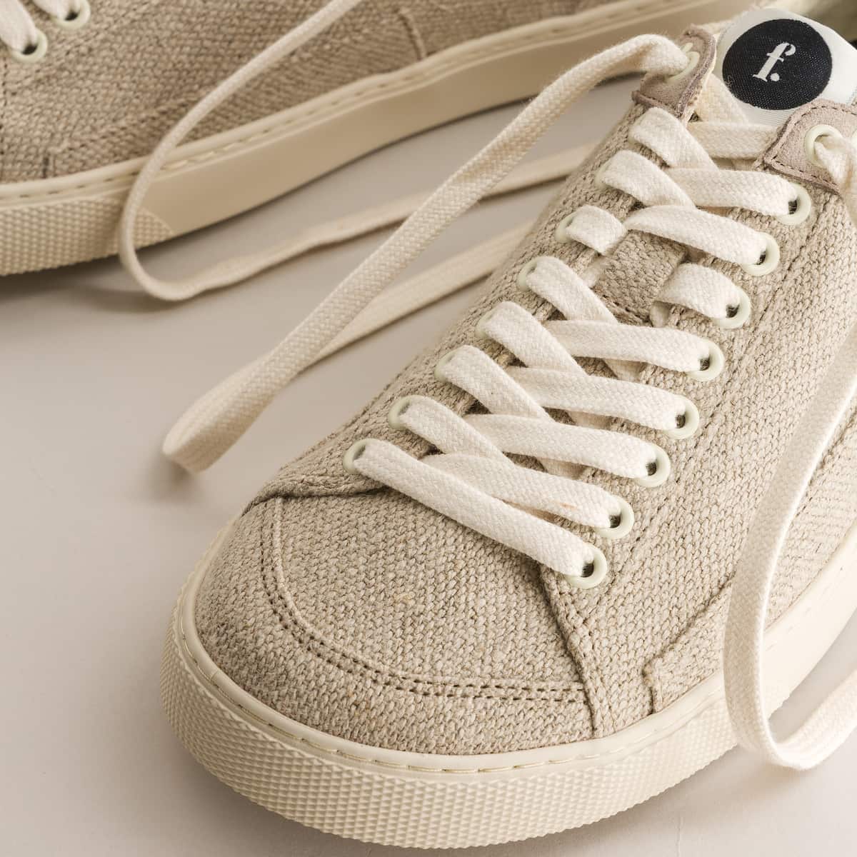 Beige barefoot sneakers with white laces on a light background