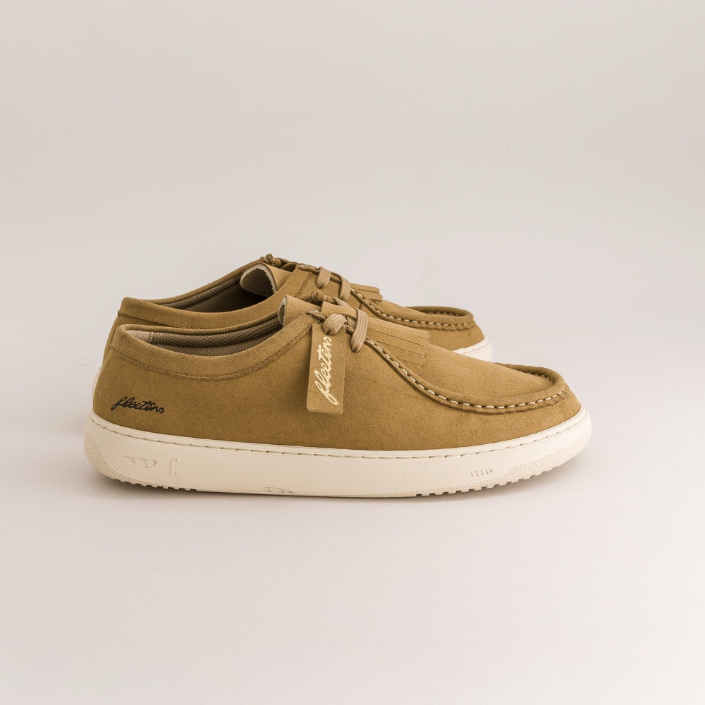 A pair of tan suede derby shoes with cream rubber soles, shown from a side profile view on a light gray background.
