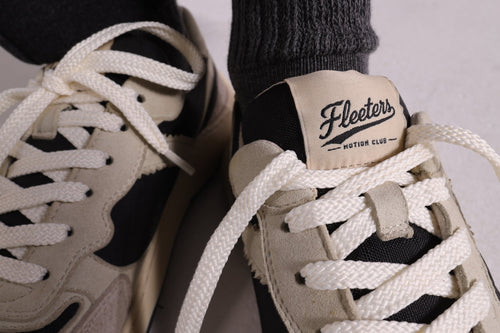 Close-up on laces of a pair of barefoot sneakers, with Fleeters logo.