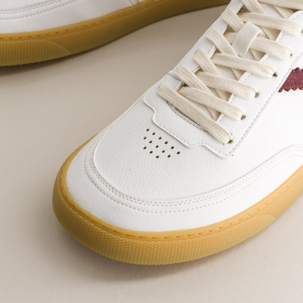 White barefoot sneaker with yellow sole on a beige background
