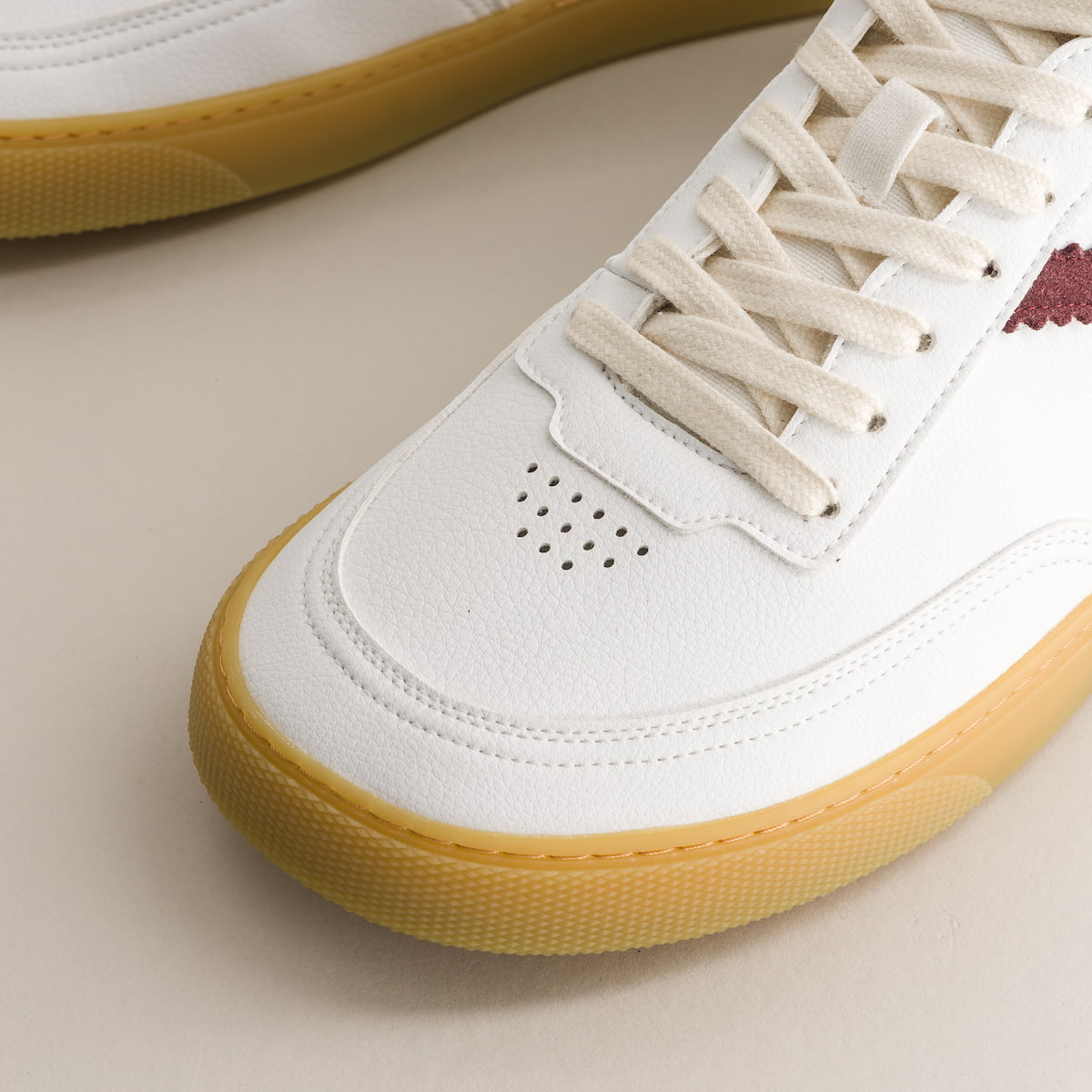 White barefoot sneaker with yellow sole on a beige background