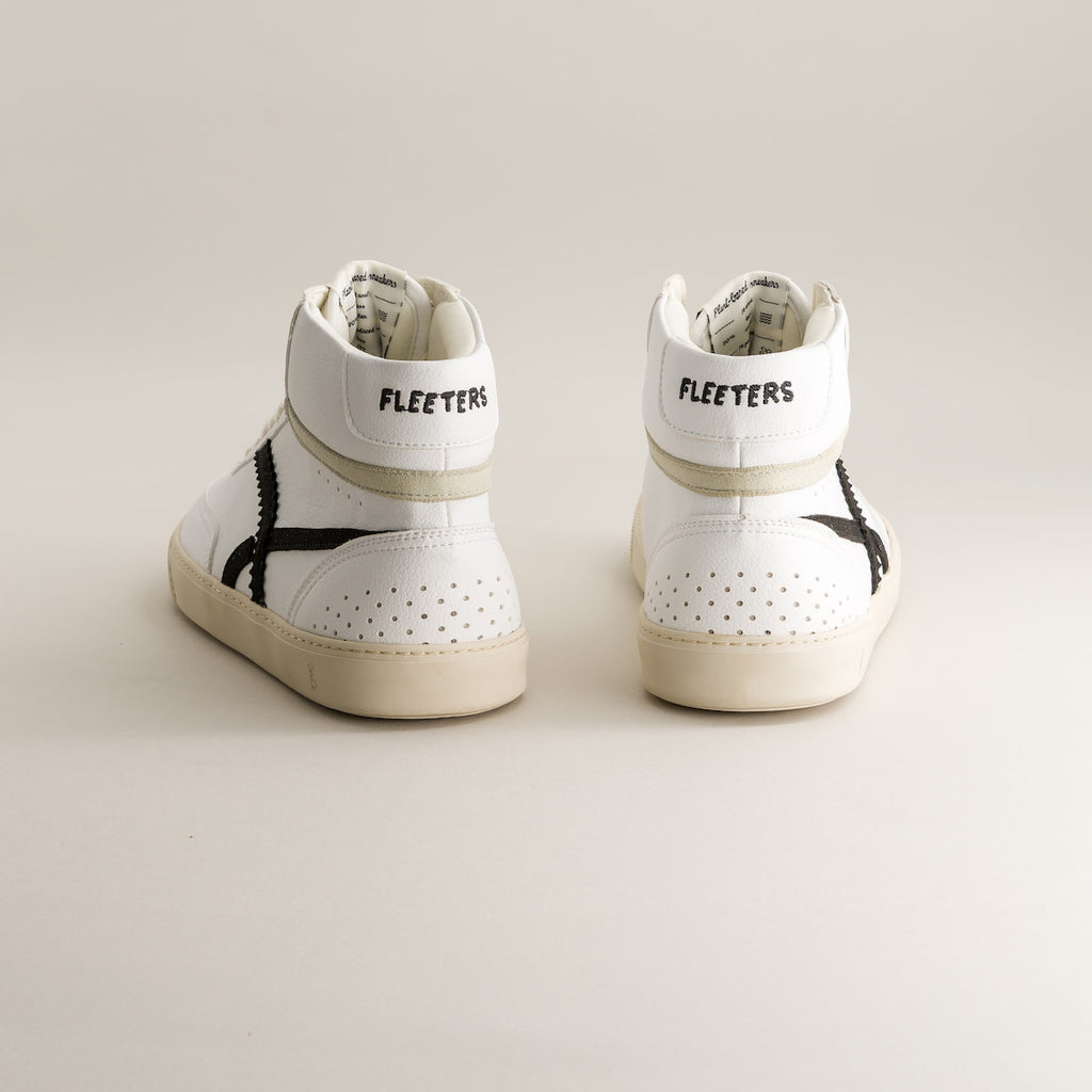 Pair of white high-top barefoot sneakers with black accents on a light background