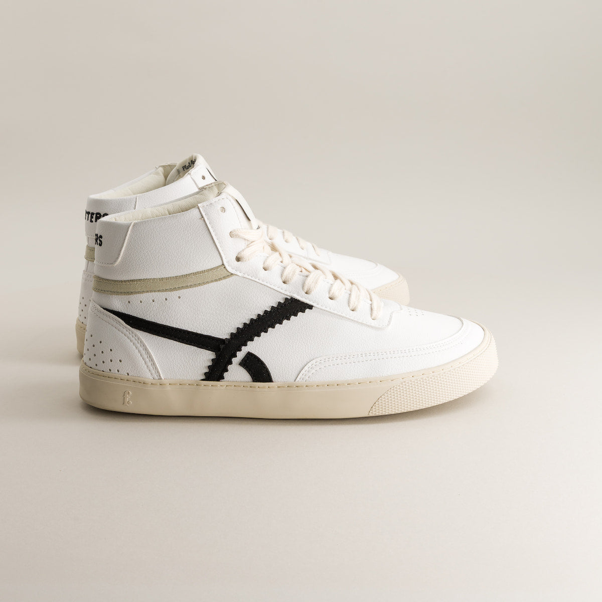 White high-top barefoot sneaker with black design on a light gray background