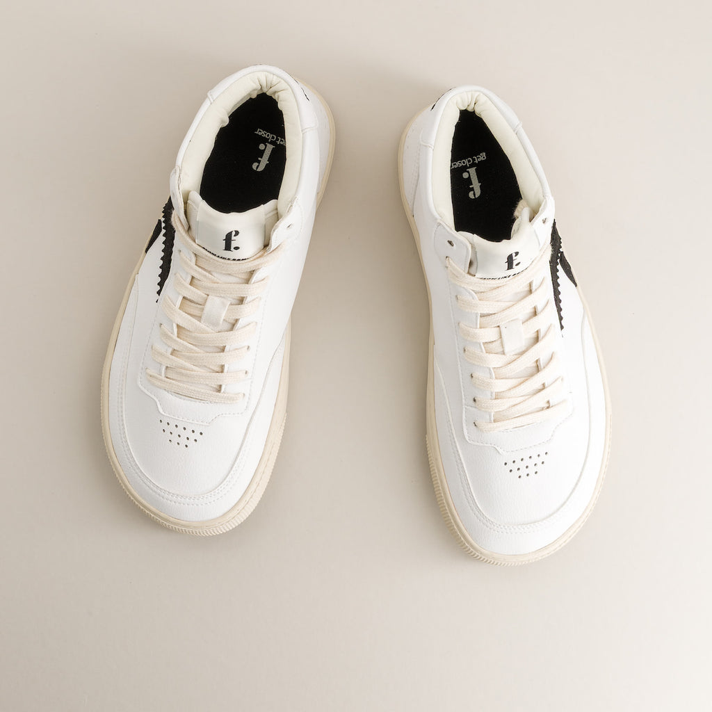 Pair of white barefoot sneakers on a beige background