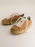 Pair of brown barefoot sneakers with white laces on a light beige background